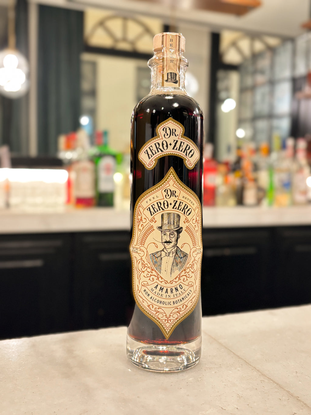 Bottle of Dr. Zero-Zero Amaretto on a bar counter with a blurred bar background