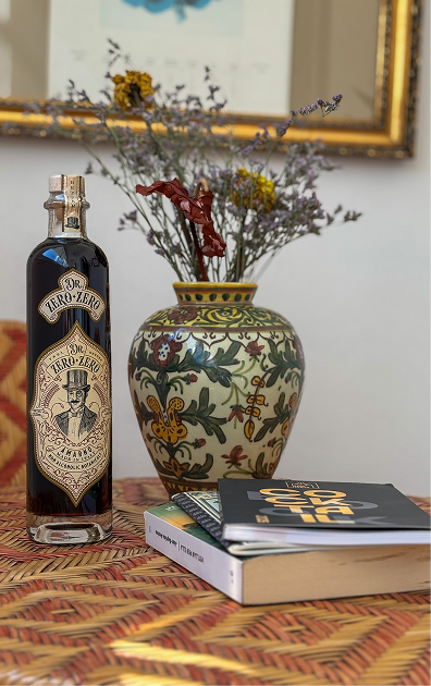 Bottle of Ego Zero on a table with a vase and books in the background